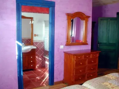 a purple bathroom with a sink and a dresser at Hostería Casa Flor in Murias de Rechivaldo