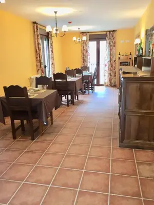 a dining room with tables and chairs and yellow walls at Hotel Rural Nova Ruta in Trabadelo