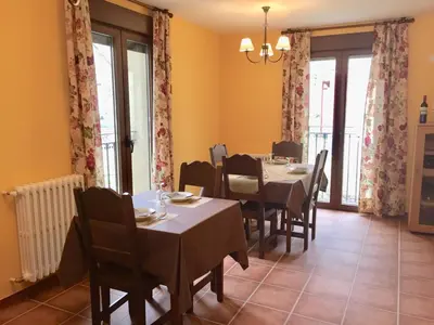 a dining room with tables and chairs and windows at Hotel Rural Nova Ruta in Trabadelo