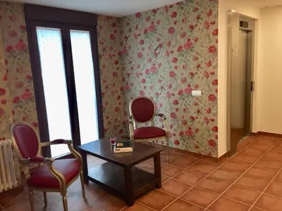 a room with two chairs and a table and flowers at Hotel Rural Nova Ruta in Trabadelo