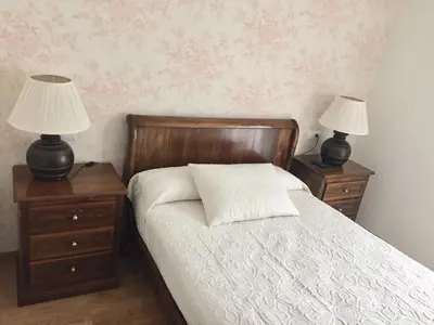 a bedroom with two nightstands and a bed with two lamps at Hotel Rural Nova Ruta in Trabadelo
