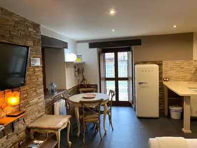 a kitchen and dining room with a table and a tv at Casas Rurales TAReira en Taramundi in Taramundi