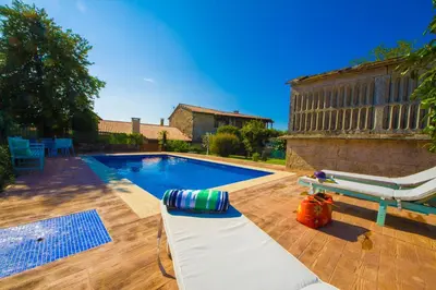 a swimming pool with a chaise lounge and a chair at Eira Grande Galicia Villas in Pedre