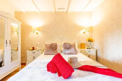 a bedroom with a white bed with red towels on it at Eira Grande Galicia Villas in Pedre