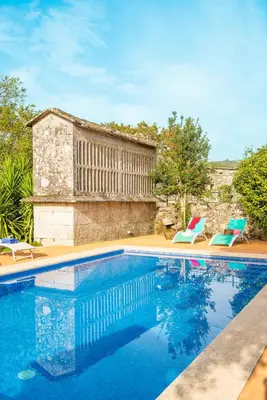 a swimming pool with two lawn chairs next to it at Eira Grande Galicia Villas in Pedre