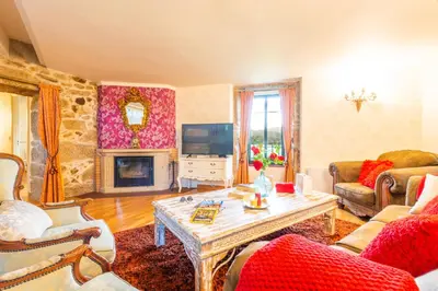 a living room with a table and a fireplace at Eira Grande Galicia Villas in Pedre