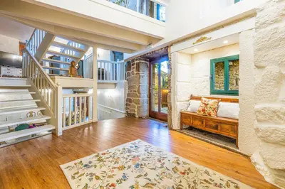 a living room with a staircase and a couch at Eira Grande Galicia Villas in Pedre