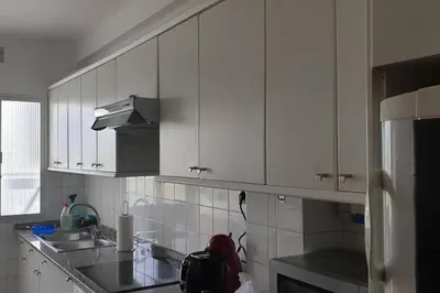 a kitchen with white cabinets and a sink and a refrigerator at Alojamiento ideal en Santiago in Santiago de Compostela