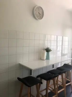 a counter with stools and a clock on the wall at Alojamiento ideal en Santiago in Santiago de Compostela