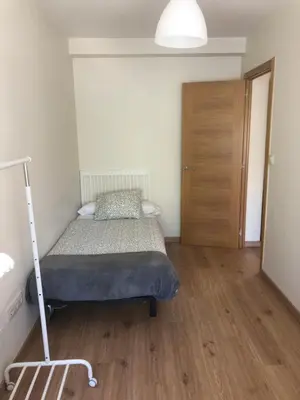 a bedroom with a bed and a wooden floor at Alojamiento ideal en Santiago in Santiago de Compostela