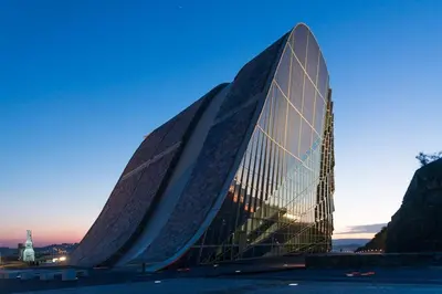 a large building with a glass facade at dusk at Alojamiento ideal en Santiago in Santiago de Compostela