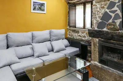 a living room with a couch and a fireplace at Spacious House with Jacuzzi, Mountain View near Tineo in Tineo