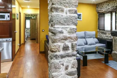 a stone wall in a living room with a couch at Spacious House with Jacuzzi, Mountain View near Tineo in Tineo