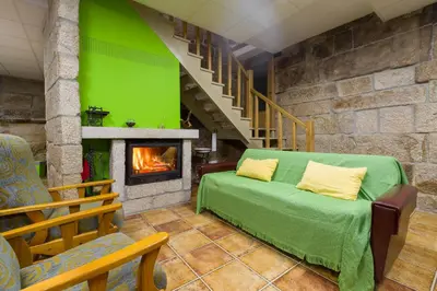 a living room with a couch and a fireplace at Gran Casa Rural A Touza in Ourense