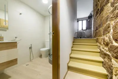 a bathroom with stairs and a stone wall at Gran Casa Rural A Touza in Ourense