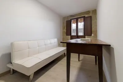 a white bench and a table in a room at Gran Casa Rural A Touza in Ourense
