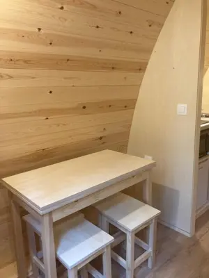 a table and stool in a kitchen with wooden walls at Camping Vila de Sarria in Sarria