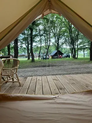 a tent with a bench on a wooden deck at Camping Vila de Sarria in Sarria