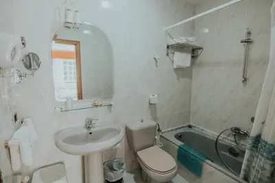 a bathroom with a sink and a toilet and a tub at Hotel A Veiga in Samos