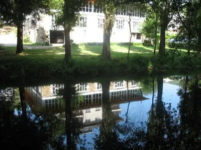 a reflection of a building in a pool of water at Hotel A Veiga in Samos