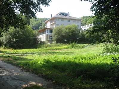 a house in the middle of a grassy field at Hotel A Veiga in Samos