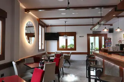a restaurant with a bar and tables and chairs at Hotel A Veiga in Samos
