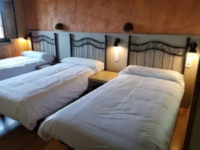 a bedroom with two beds with lights on them at A Reboleira - Casa Nuñez in Fonfría
