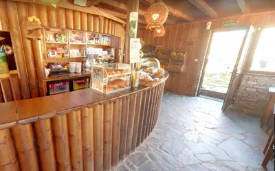 a restaurant with a counter in a wooden building at A Reboleira - Casa Nuñez in Fonfría