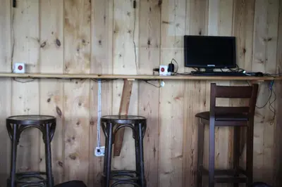 a wooden wall with two bar stools and a computer monitor at A Reboleira - Casa Nuñez in Fonfría