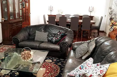 a living room with a leather couch and a table at POSTA Do SOL in Baralla
