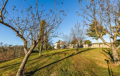 a field with trees and a house in the background at POSTA Do SOL in Baralla