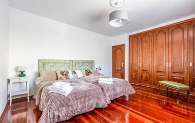 a bedroom with a large bed and wooden cabinets at POSTA Do SOL in Baralla
