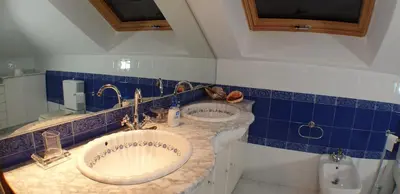 a bathroom with two sinks and a blue tiled wall at POSTA Do SOL in Baralla