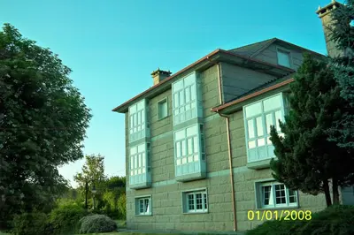 a large brick building with white windows on it at POSTA Do SOL in Baralla