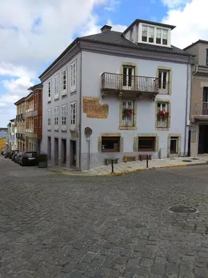 a large white building on a city street at Apartamento Cine Colón 2 in Ribadeo