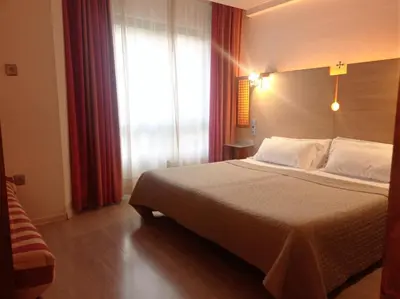 a bedroom with a bed and a large window at Hotel Castillo del Alba in Pola de Somiedo