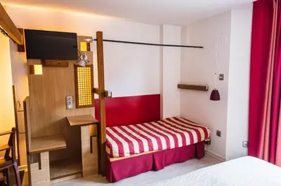 a small room with a bed and a bench at Hotel Castillo del Alba in Pola de Somiedo