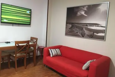 a living room with a red couch and a table at PISO A 400 METROS DE LA CATEDRAL in Santiago de Compostela