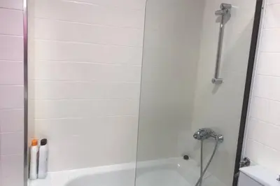 a shower with a glass door next to a tub at PISO A 400 METROS DE LA CATEDRAL in Santiago de Compostela