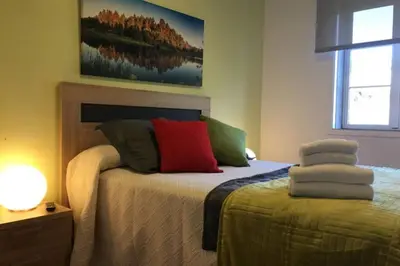 a bedroom with a bed with colorful pillows on it at PISO A 400 METROS DE LA CATEDRAL in Santiago de Compostela