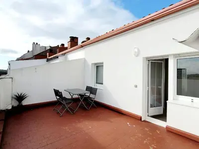a patio with a table and chairs on a white building at Acogedor apartamento a la entrada de camino portugués in Santiago de Compostela