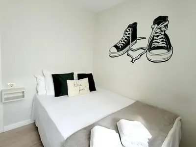a bedroom with a bed with shoes on the wall at Acogedor apartamento a la entrada de camino portugués in Santiago de Compostela