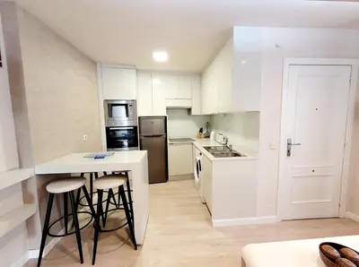 a kitchen with white cabinets and a white counter top at Acogedor apartamento a la entrada de camino portugués in Santiago de Compostela