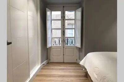 a bedroom with a white bed and a window at Plaza Mayor in Ourense