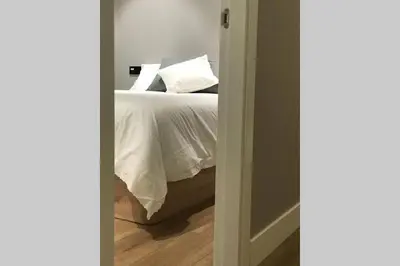 a bedroom with a bed with white sheets and pillows at Plaza Mayor in Ourense