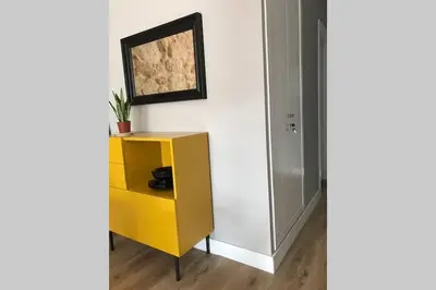 a yellow cabinet next to a wall with a painting at Plaza Mayor in Ourense