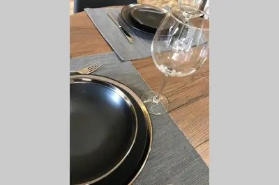 a table with a black plate and a glass of wine at Plaza Mayor in Ourense