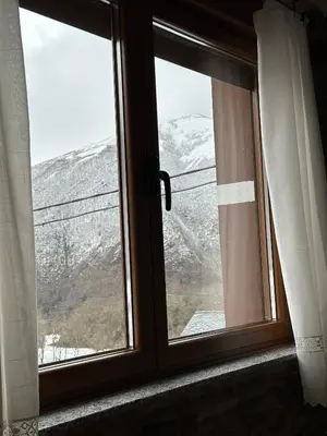 a window with a view of a snow covered mountain at La Casa del Maestro in Rabanal