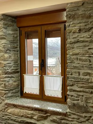 a window in a stone wall with a view at La Casa del Maestro in Rabanal