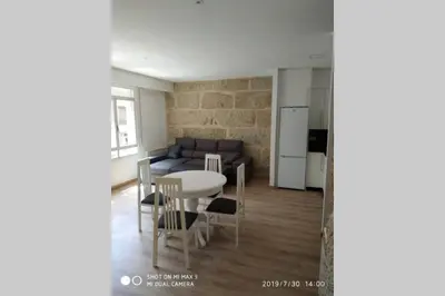 a kitchen and a living room with a table and a couch at Villa Trabazos Abellas in Ourense
